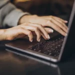 Kobieta pisząca na laptopie – przykład tworzenia treści, które budują przewagę w SEO i zaufanie użytkowników.